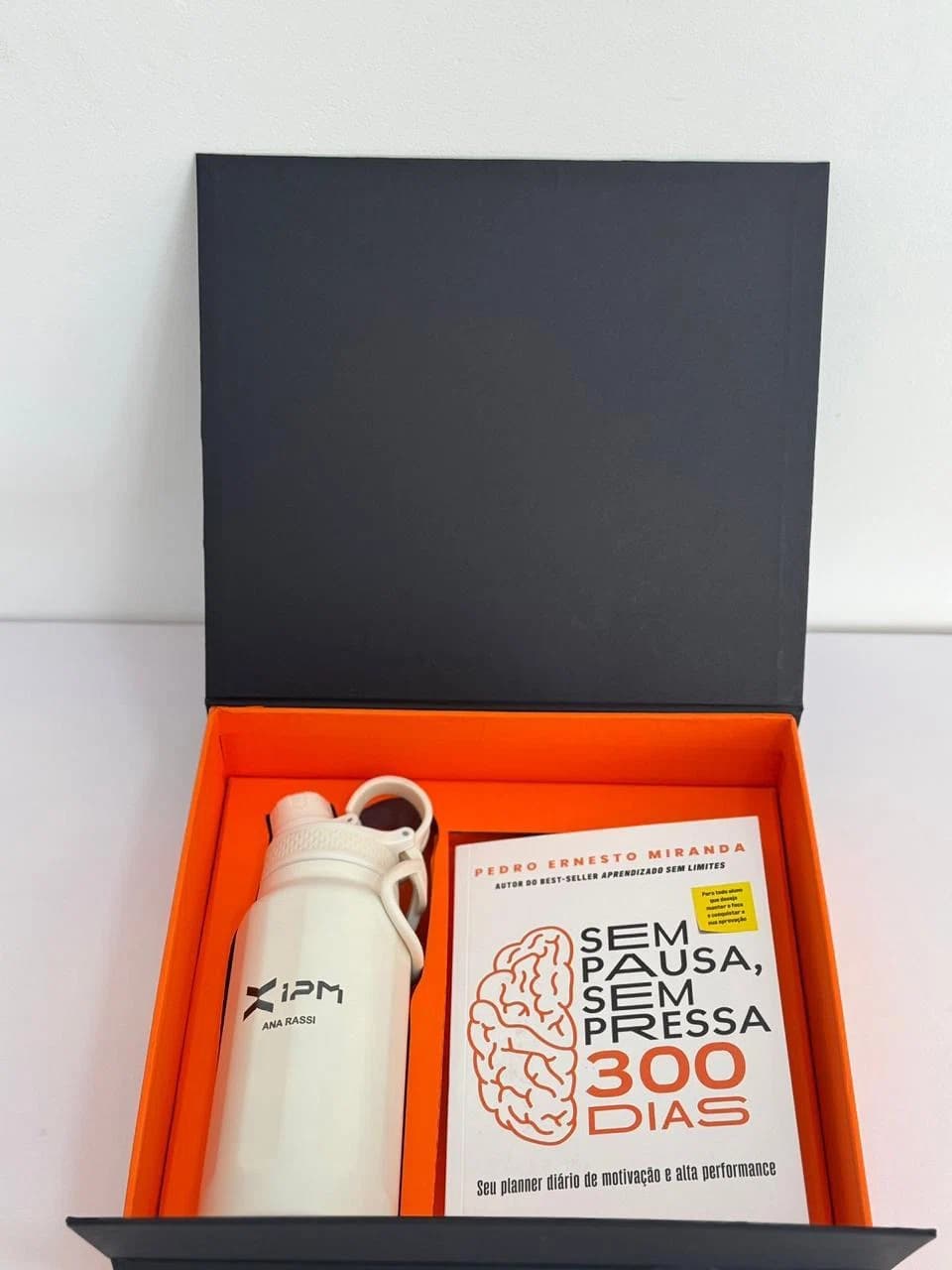 Kit corporativo com squeeze e cartão em caixa preta com interior laranja
