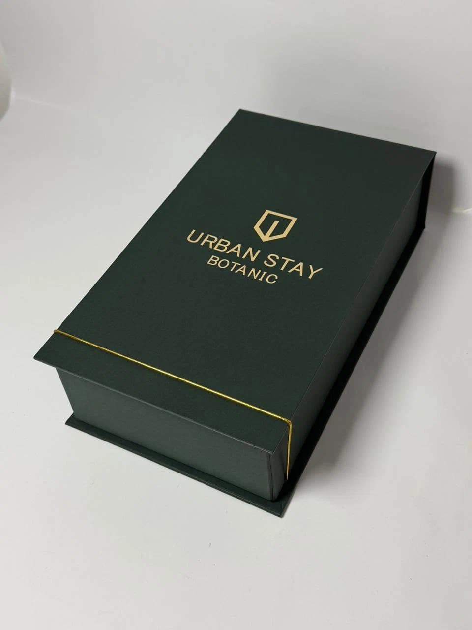 Caixa cartonada verde estilo livro com personalização dourada da Casa das Lembrancinhas em Goiânia