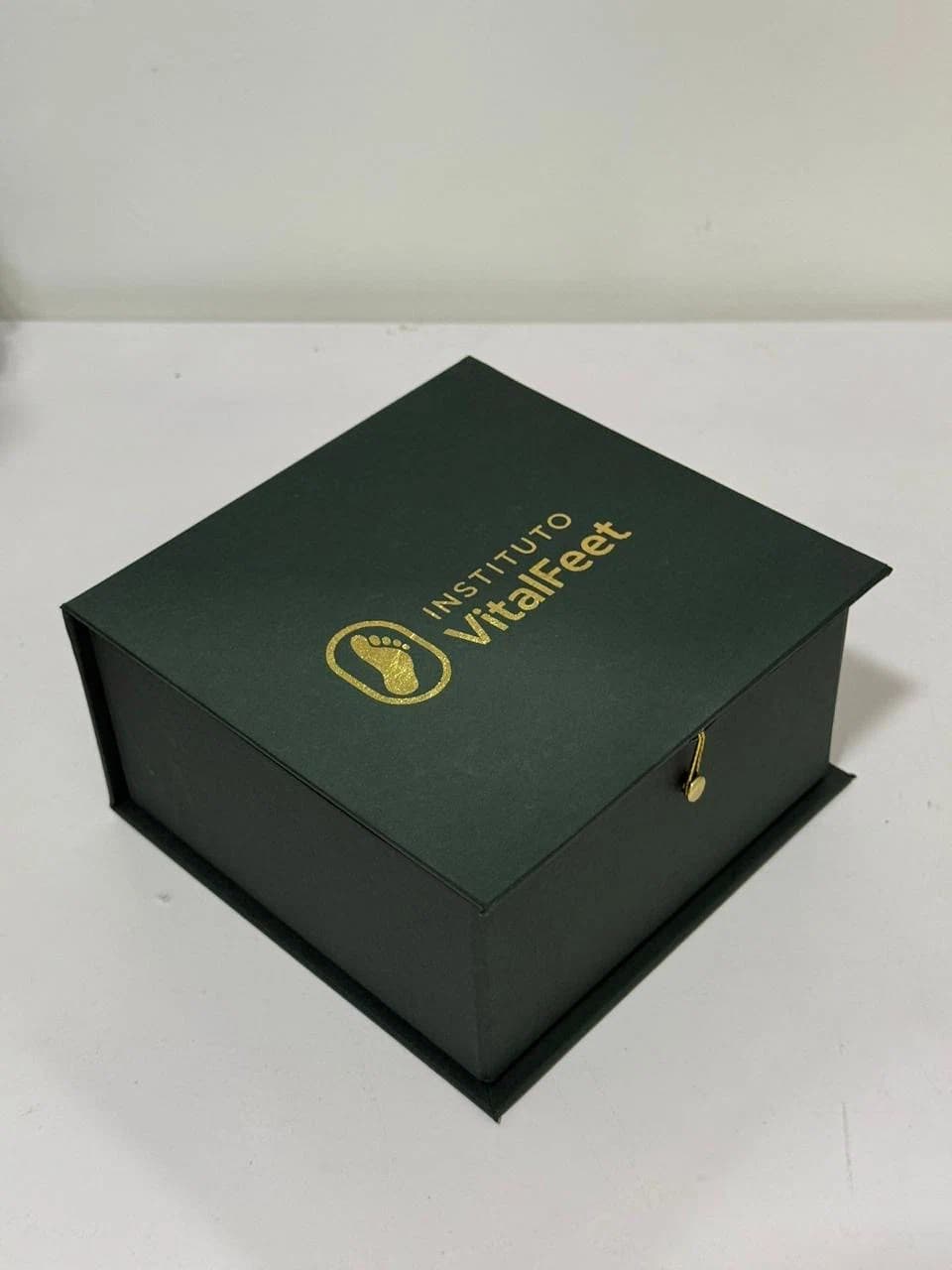 Caixa cartonada verde fechada com personalização dourada da Casa das Lembrancinhas em Goiânia