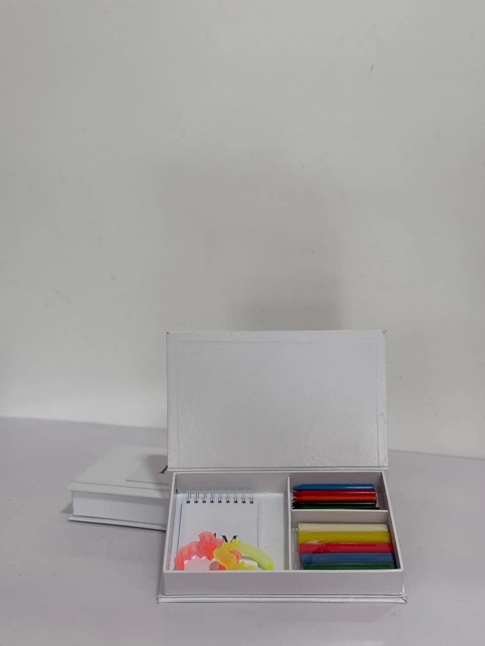 Kit de papelaria personalizada aberto em caixa branca da Casa das Lembrancinhas em Goiânia